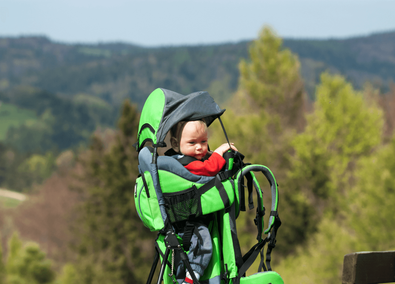 Bébé dans un porte-bébé non physiologique vert