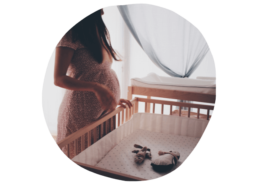 Femme enceinte devant le lit du futur bébé